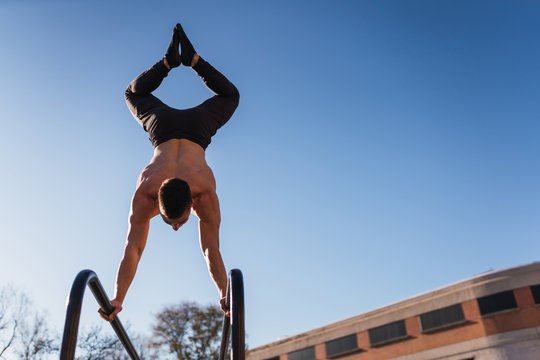 Young guy exercising on parallel bars