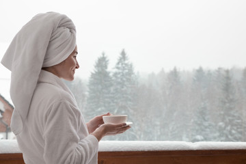 Woman with cup of coffee in winter morning. at the hotel or spa - 243473476