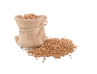 dried coriander seeds in sack and on white background