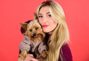 Which dog breeds should wear coats. Dressing dog for cold weather. Make sure dog feel comfortable in clothes. Apparel and accessories. Girl hug little dog in coat. Woman carry yorkshire terrier