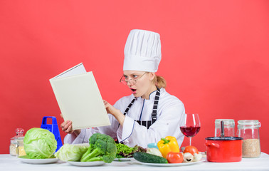 Woman chef cooking healthy food. Girl read book best culinary recipes. Culinary education concept. Female in hat and apron knows everything about culinary arts. Improve cooking skill. Culinary expert
