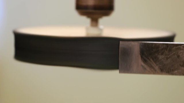 Honing a chisel after it has been sharpened with a honing wheel or power strop on a pillar drill