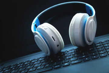 Obraz na płótnie Canvas White headphones on laptop keyboard.