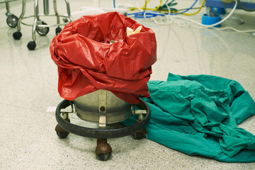 A red surgical garbage bin in operating room