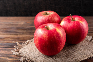 Red apples on dark wooden background.
