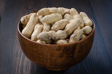 Peanuts in the peel on a dark background.