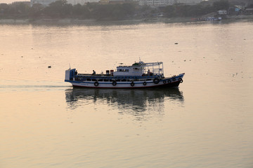 Old ferry boat crosses the Hooghly River nearby the Howrah Bridge in Kolkata