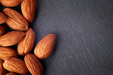 Almonds kernel on dark rustic background. Top view with copy space