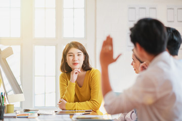Group of diverse young adults in a meeting with a manageress or university tutor sitting grouped...