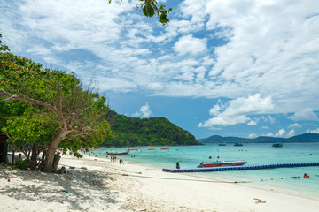 a floating pier and a motor boat on the beach of an thai island in the Andaman sea