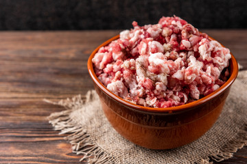 Raw minced meat on dark wooden background.