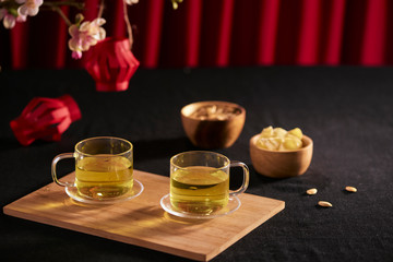 Lunar new year food and drink still life on black background. Translation of text paper in image: Prosperity