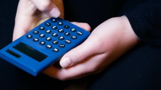 girl holds a solar calculator and accounts, footage suitable for sensitizing teenagers to the economy