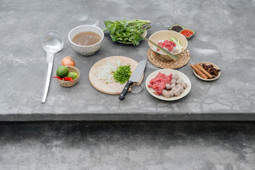 Traditional Vietnamese soup Pho bo with herbs, meat, rice noodles, broth. Pho bo in bowl with chopsticks, spoon. Space for text. Top view. Asian soup Pho bo on wooden table background. Vietnamese soup