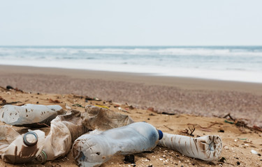 Fototapeta na wymiar Beach pollution. Plastic bottles and other trash on sea beach