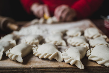 Homemade food - closeup of making traditional Polish pierogi. Soft moody tones.