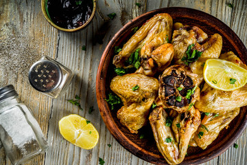 Grilled bbq chicken wings with sauces and spices, wooden background copy space top view