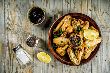 Grilled bbq chicken wings with sauces and spices, wooden background copy space top view