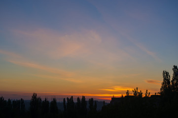 Landscape with dramatic light - beautiful golden sunset with saturated sky and clouds.