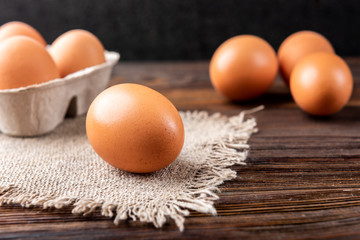 Raw eggs on dark wooden background.
