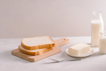 Sliced bread bake and butter on wooden cutting board. Simple breakfast