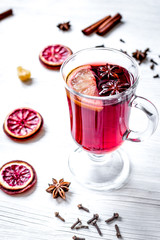 mulled wine with spices in cup on wooden background