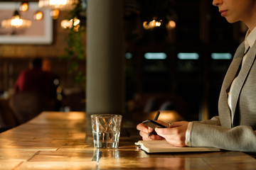 Business woman holding a phone in her hands.