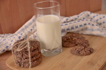 glass of milk and cookies on wooden table