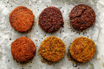 Baked vegan burgers, cutlets made of beetroot, green peas, carrots, groats and herbs on white...