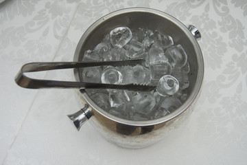 ice cubes in the bucket with tongs