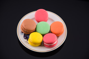 colorful macaroons on black acrylic background
