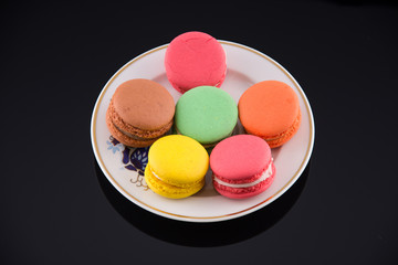 colorful macaroons on black acrylic background