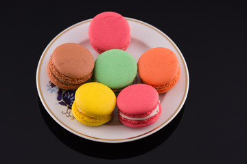 colorful macaroons on black acrylic background