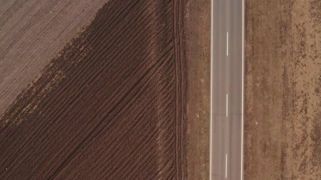 Aerial view of single red vehicle on the road through countryside