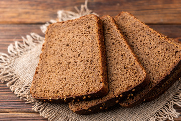 Rye bread on dark wooden background.