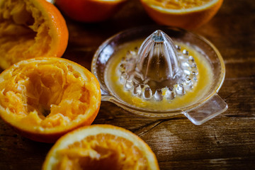 Oranges and squeezer on wooden table