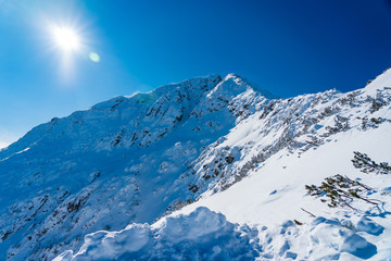 Obraz premium snow mountain peak with clear sky and sun flares pirin bulgaria