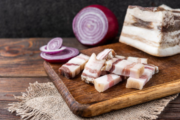 Salt pork fat with onion on wooden background. 