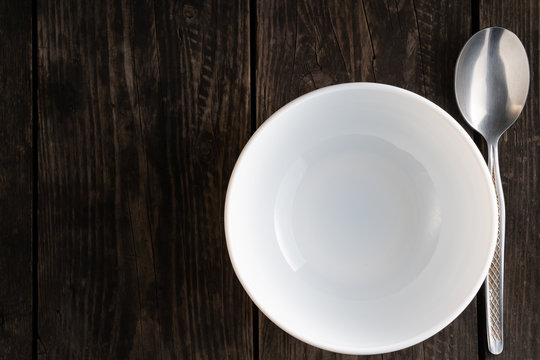 table setting empty white plate with spoon on wooden table