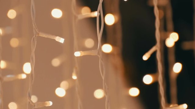 Christmas garland with Golden lights, in mall close-up. Blurred Christmas lights in shopping center. Bokeh.