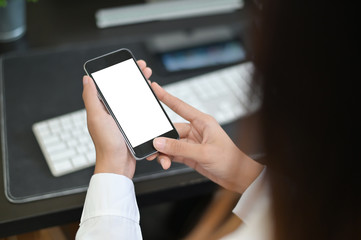 Mockup smartphone on female hands empty display on office table with blur background. - Image