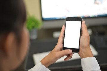 Mockup smartphone on female hands empty display on office table with blur background. - Image