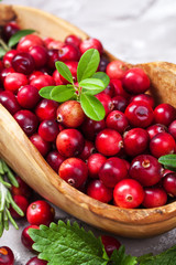 Harvest fresh red cranberries in wooden bowl, selective focus. Autumn concept