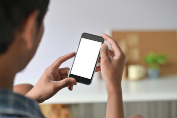 Man hands holding smart phone with blank copy space screen for your text message or information content, male reading text message on telephone during in office desk urban setting.