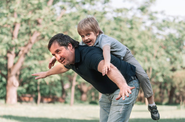 Fototapeta premium dad plays with his little son on a walk in the Park .