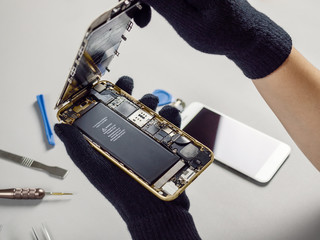 Technician or engineer opening broken smartphone for repair or replace new part on desk