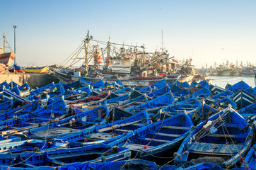 Wooden blue boats of Essaouira city harbour at sunrise in Morocco, Africa. Ocean peaceful seascape at sunset