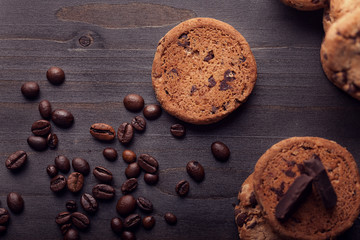 Top view of Chocolate chip cookies with beans on dark old wooden table. Delicious snack.