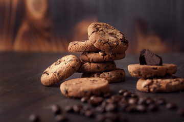 Chocolate chip cookies on old wooden table with coffee beans. Homemade snack.