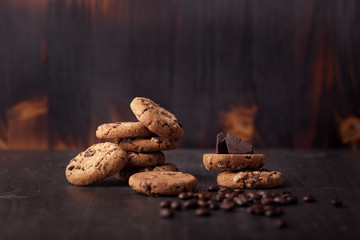 Chocolate chip cookies on old wooden table with coffee beans. Homemade snack.